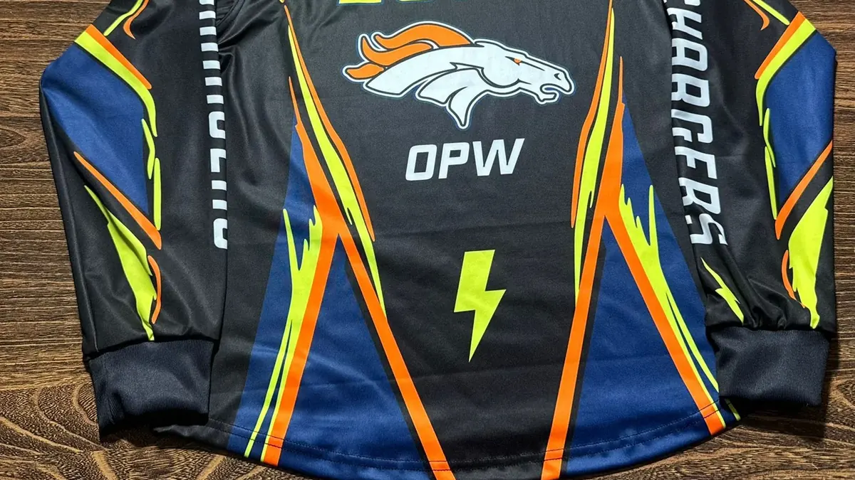 Finished long-sleeve team jersey laid flat, back view, showing a large player number, a crest and lettering down the sleeves