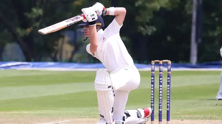 Cricket player wearing a white club uniform