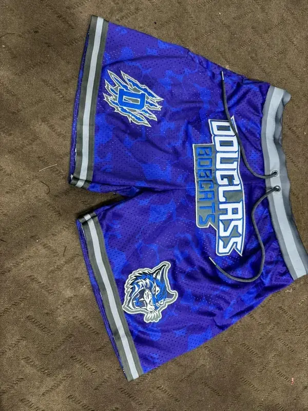 Matching custom sublimated alumni basketball shorts with crest, flat lay