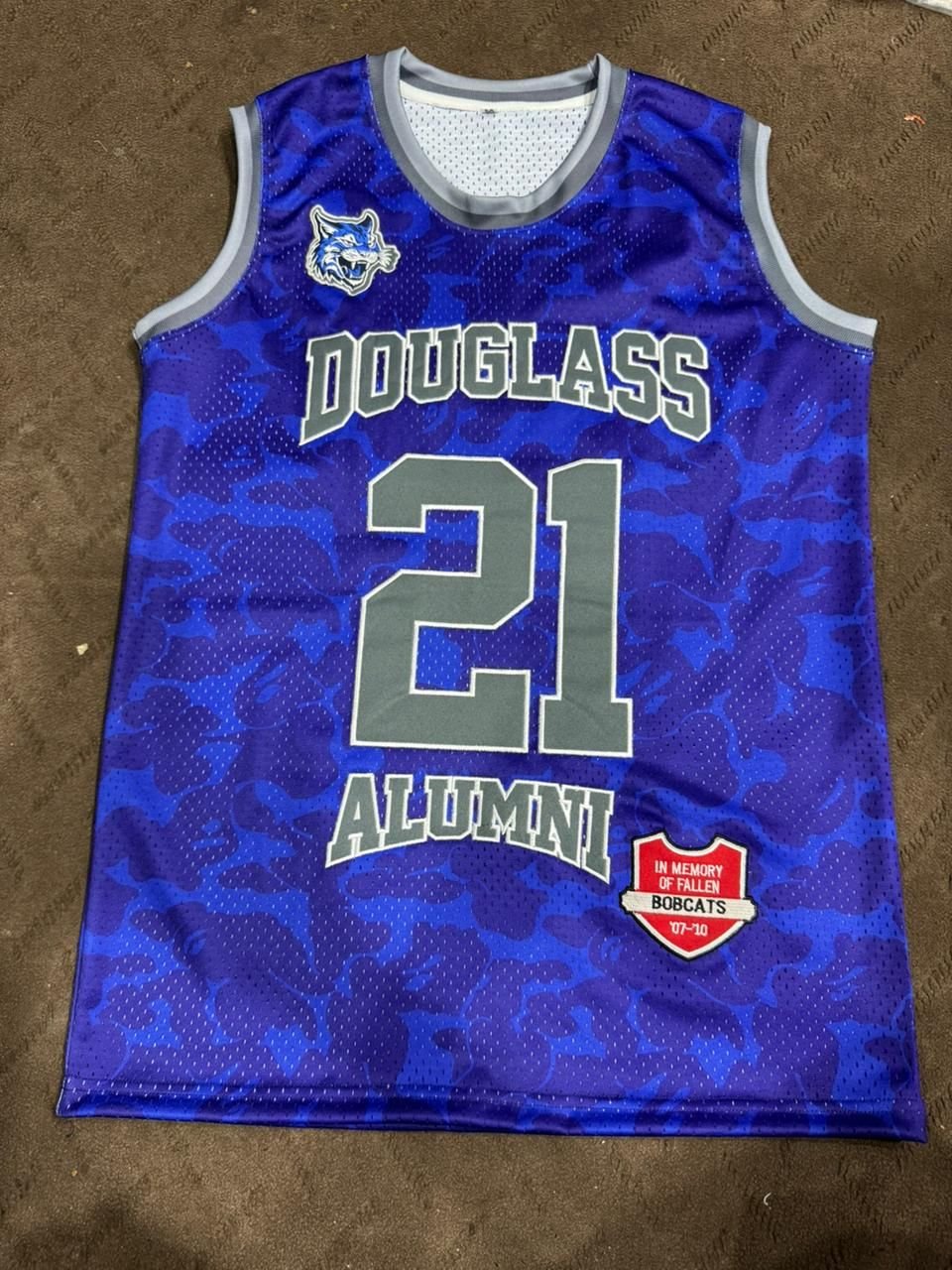 Custom camo-pattern basketball alumni jersey, numbered, flat lay