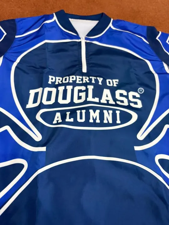 Custom blue sublimated alumni quarter-zip jersey with a large chest print, flat lay