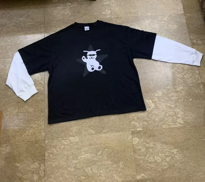 Custom oversized black long-sleeve tee with layered white sleeves and a white bear graphic, flat lay