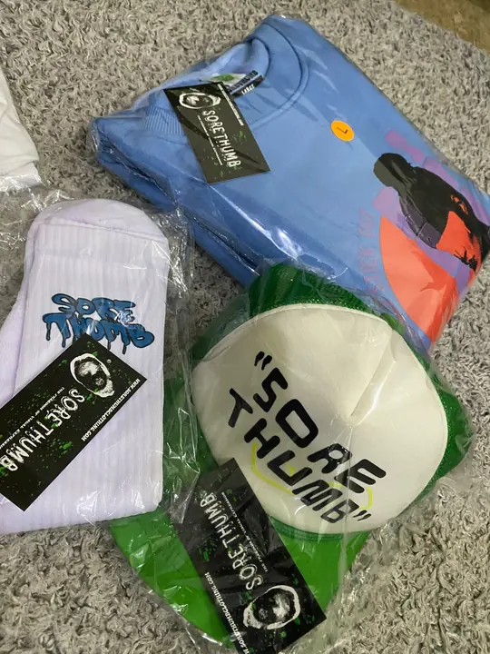 Finished private-label set laid out for photography: hoodie, socks, cap and branded hang tags