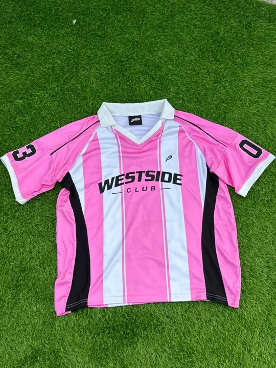 Custom sublimated striped club jersey with player number, laid flat on grass