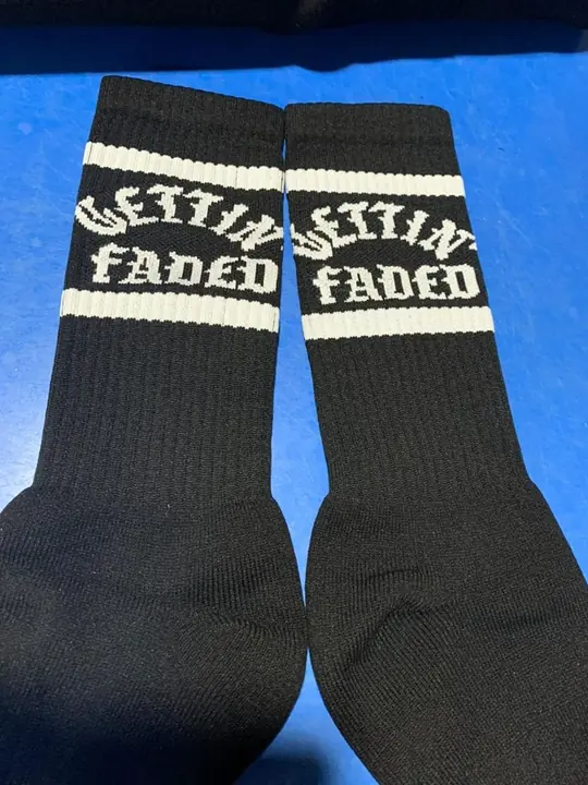 Pair of black custom woven crew socks with branded cuff lettering