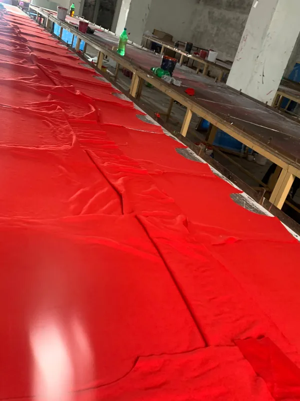 Cut red fabric panels on the cutting table at the True Fit factory