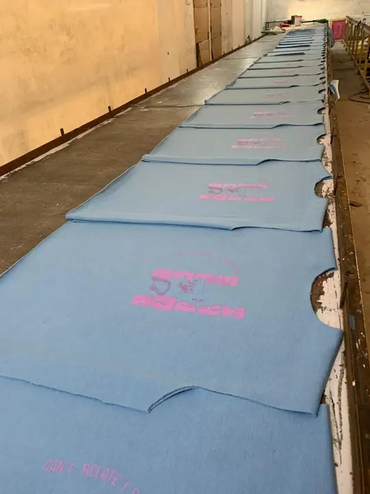 Sweatshirts laid out on the blue print table with graphics being applied