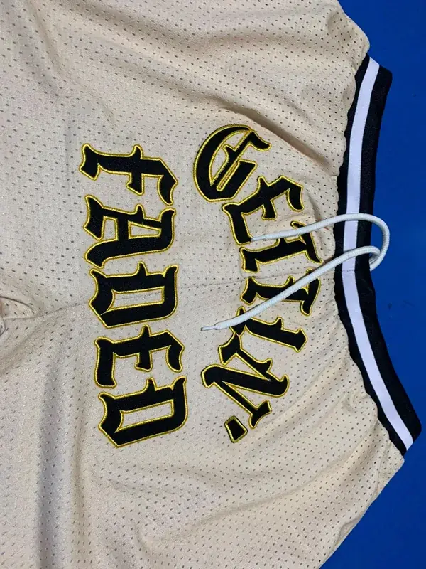 Custom mesh basketball jersey, cream and black colorway, "Gettin' Faded" embroidered wordmark, folded flat lay