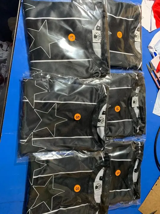 Stack of black star-print jerseys individually bagged for shipment