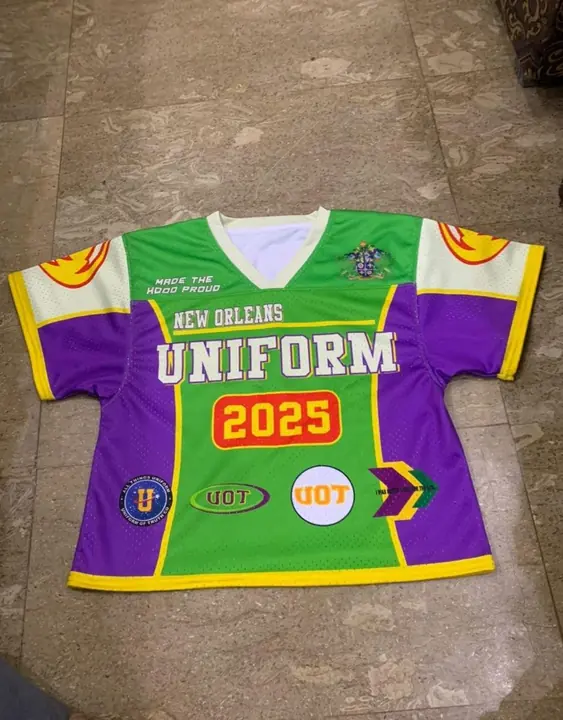 Custom sublimated mesh lacrosse jersey in green, yellow and purple, front, flat lay