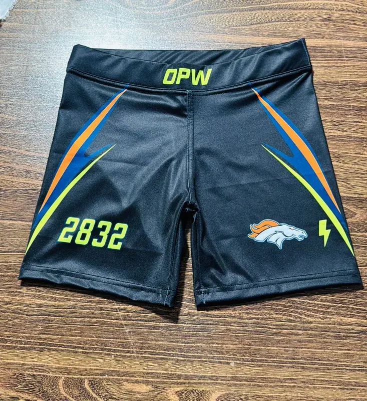 Custom black satin team shorts, back view with number and logo, laid flat