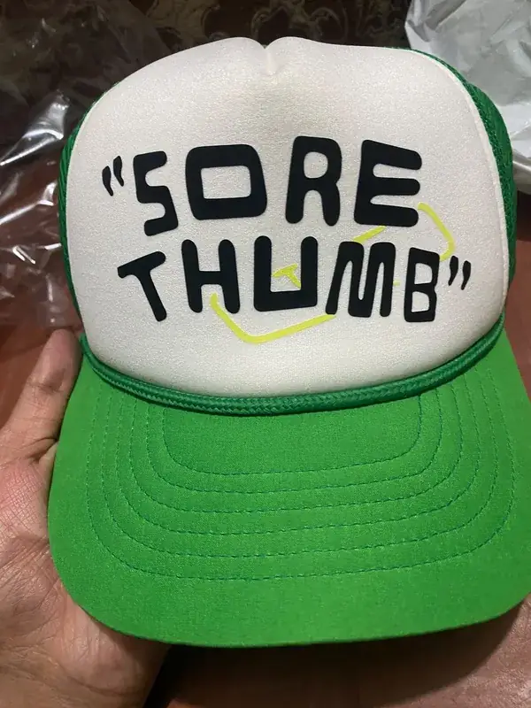 Custom embroidered trucker cap, green and white, "Sore Thumb" private-label branding