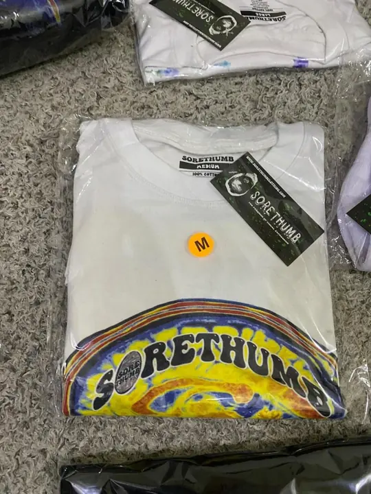 White custom tee folded with a branded hang tag, ready to bag